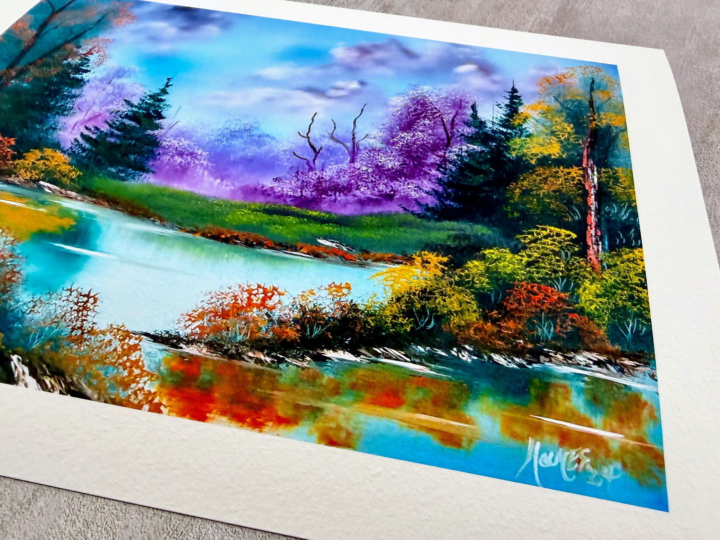 Colorful landscape painting of a forest and lake on a textured surface