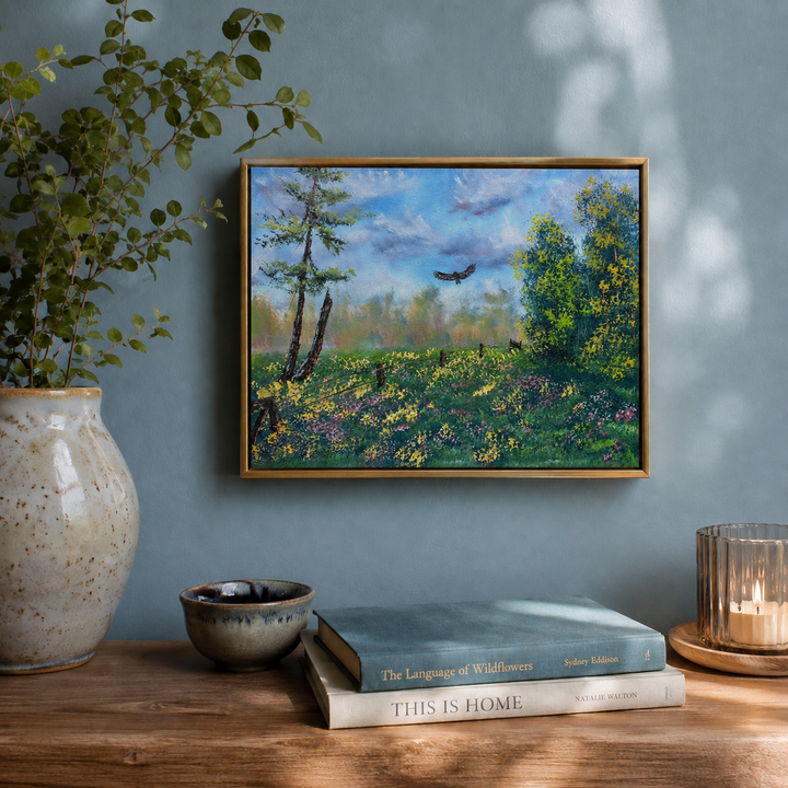 original oil painting on 9"x12" canvas showing a country meadow with a bird flying over. the artwork is hanging on a pastel blue wall over a shelf with a couple of nature books and ceramic vase