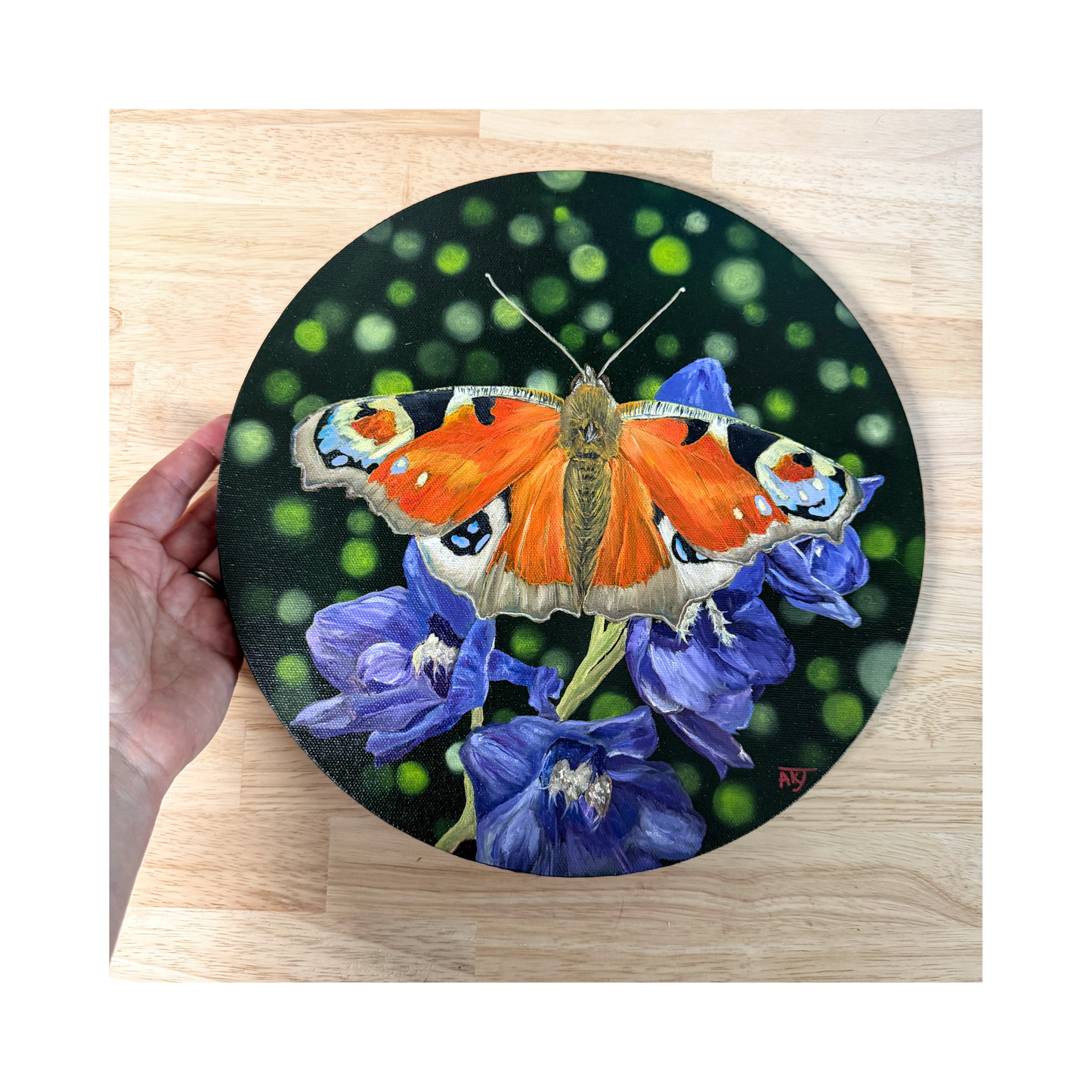 Original oil painting of a peacock butterfly sitting on purple delphinium flowers on a 12" round canvas top view