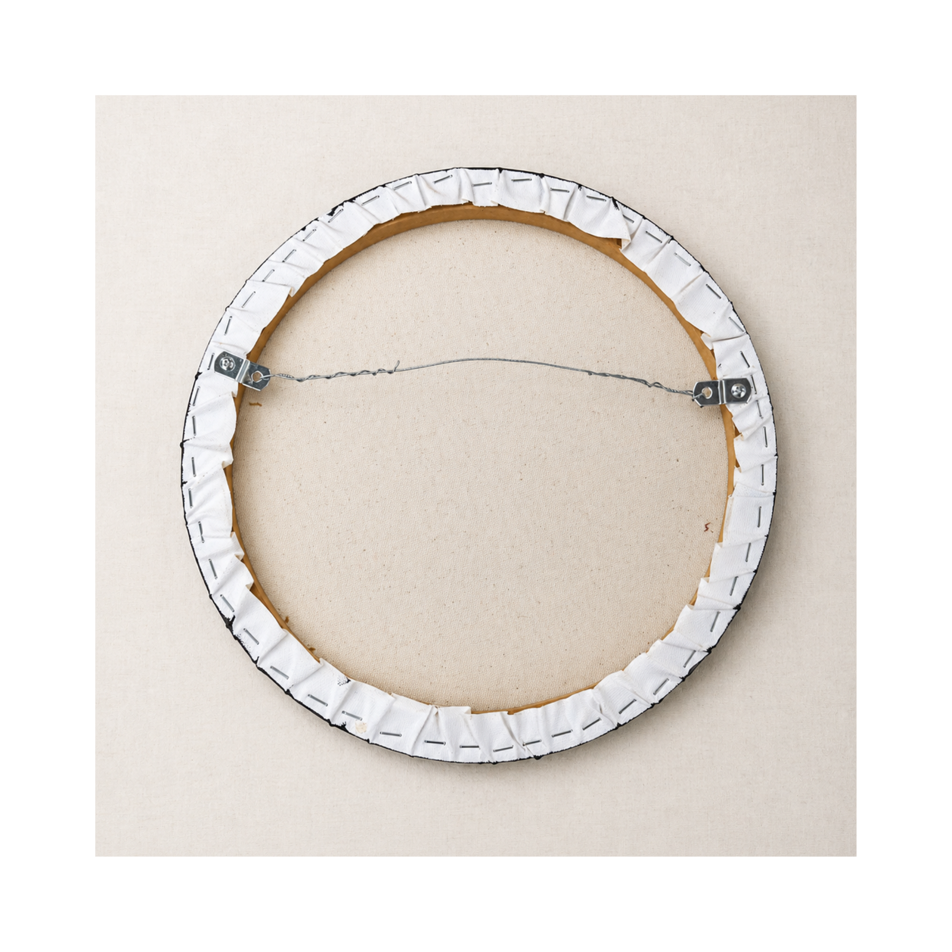 "Ready to hang" - a photo of the back of the round canvas showing the wire for picture hanging
