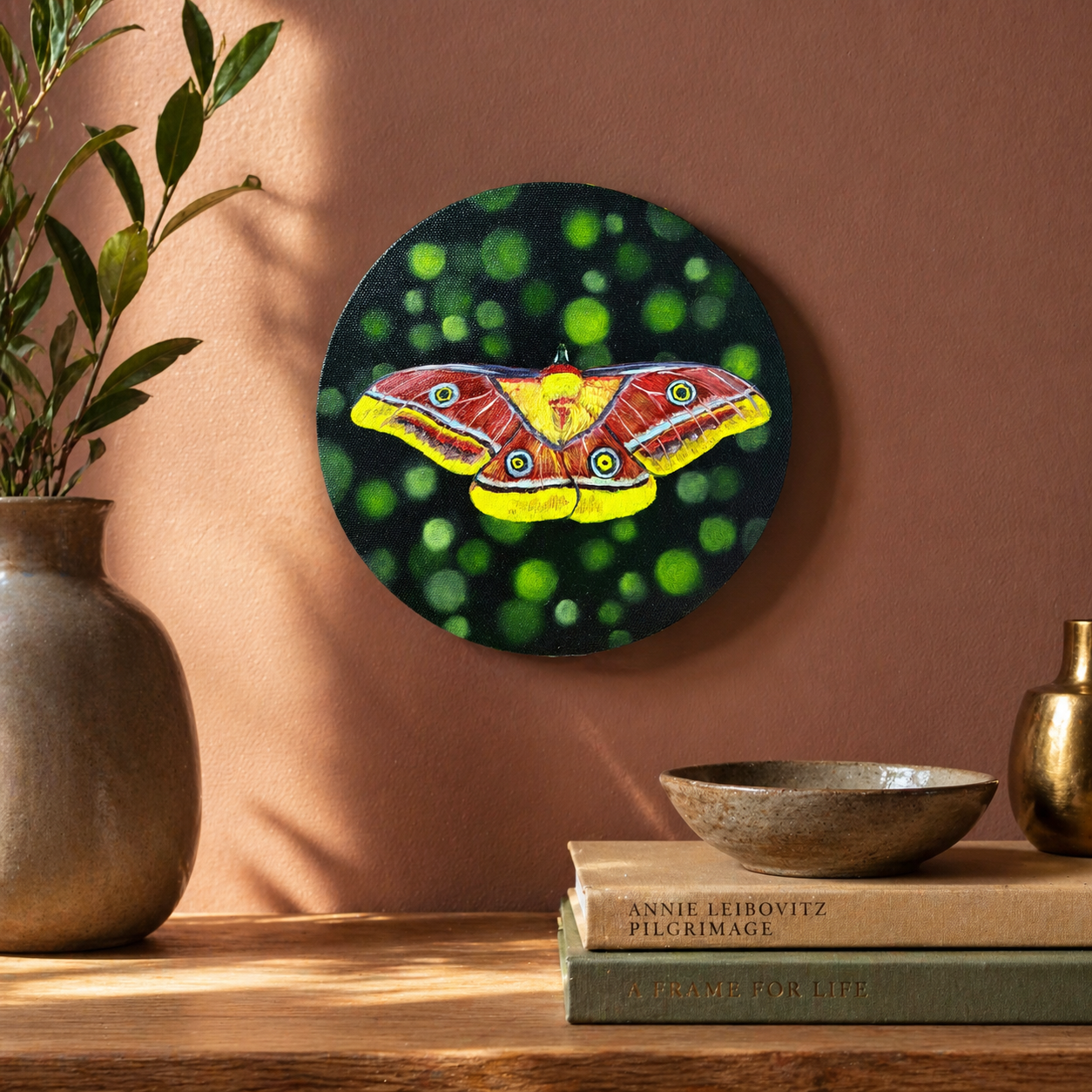 Tina yellow and red moth oil painting over console table with books