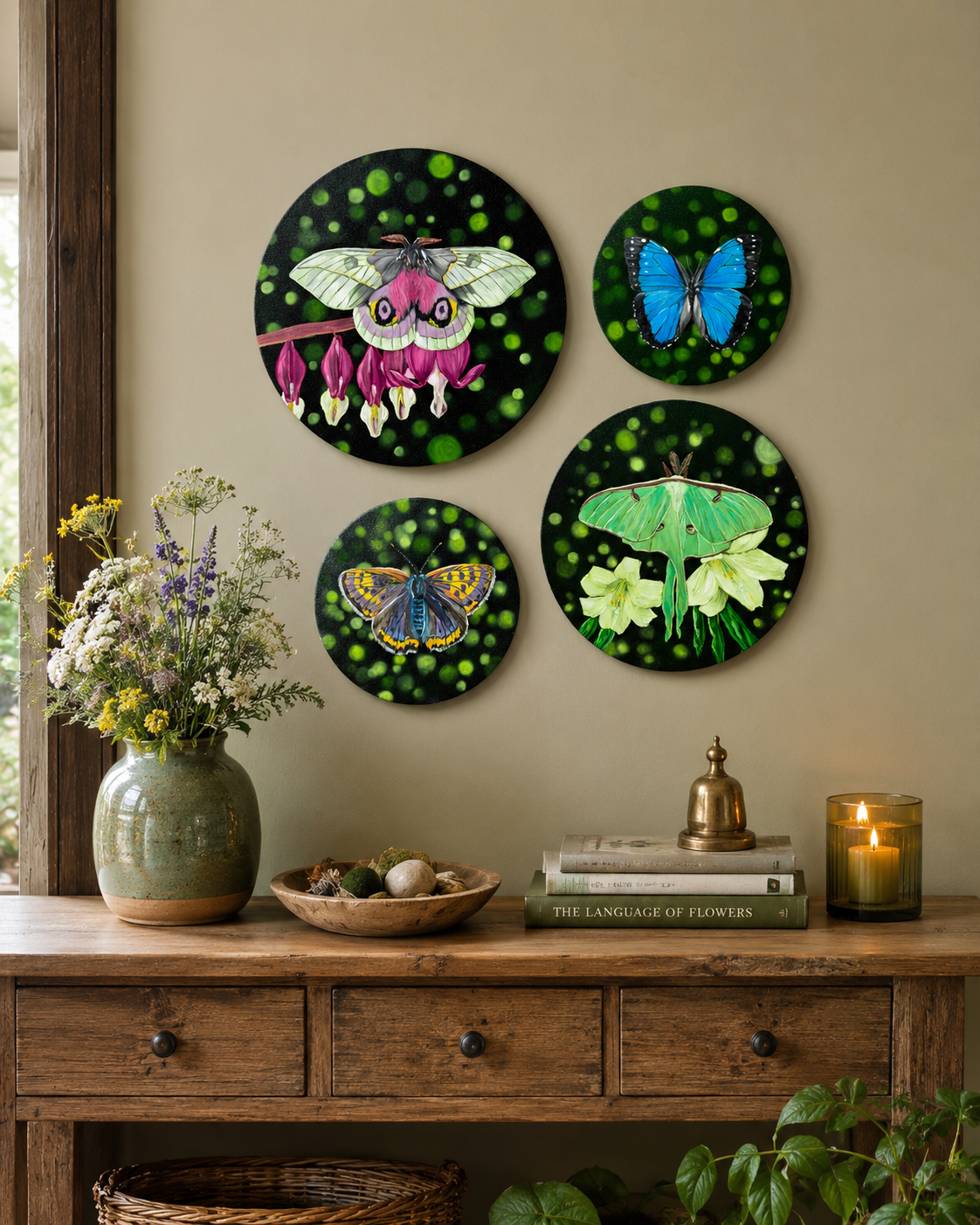 Decorative wall art of butterflies on a moss green wall above a wooden console table.