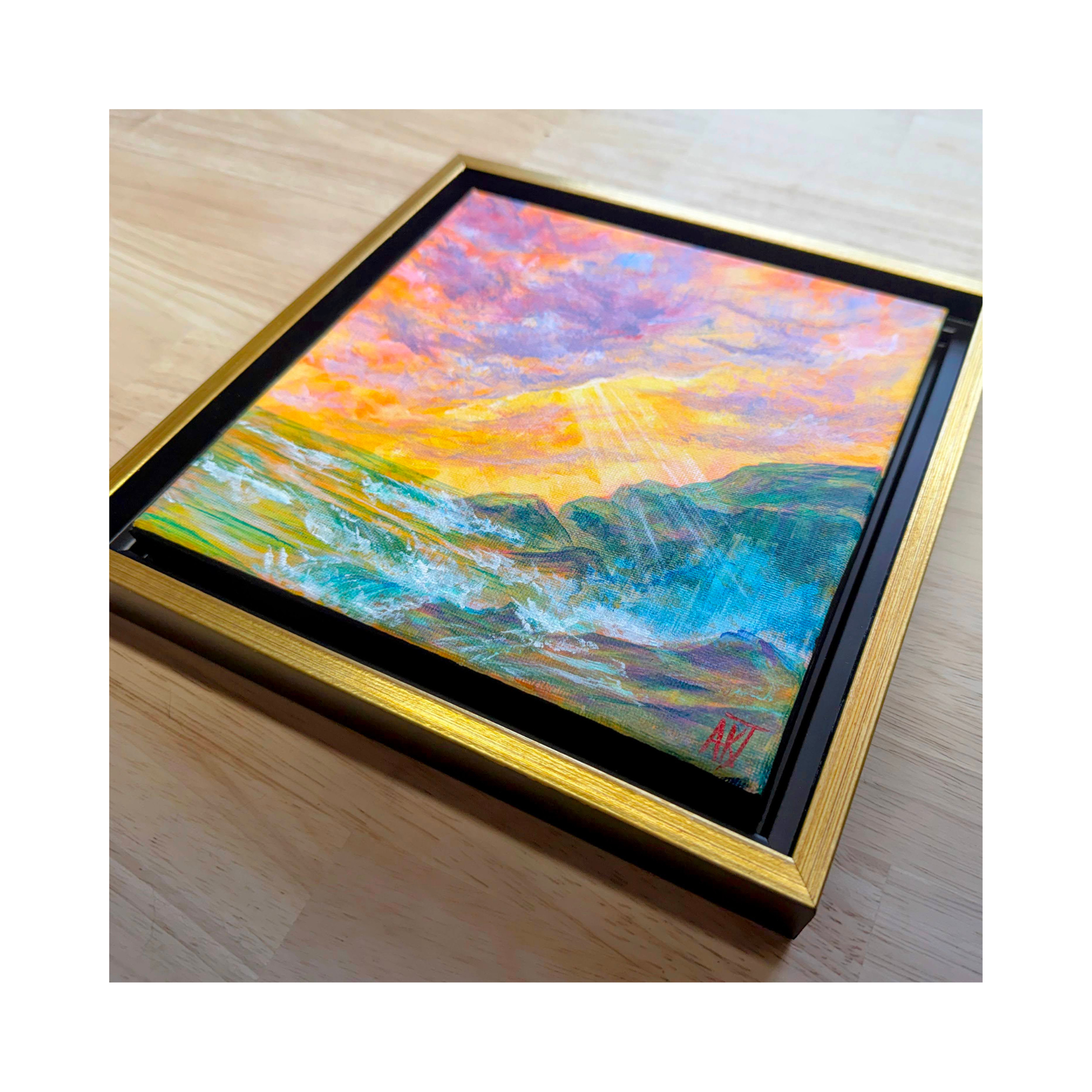 Framed seascape painting on a wooden surface