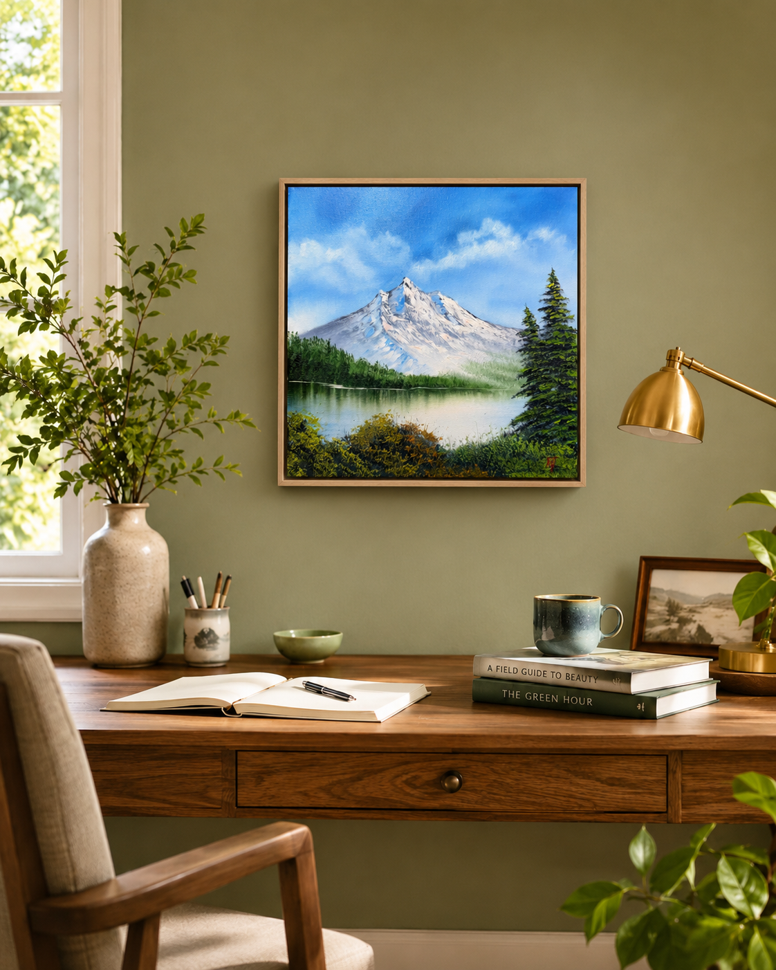 Home office with a desk, chair, lamp, and framed mountain landscape painting on a green wall.