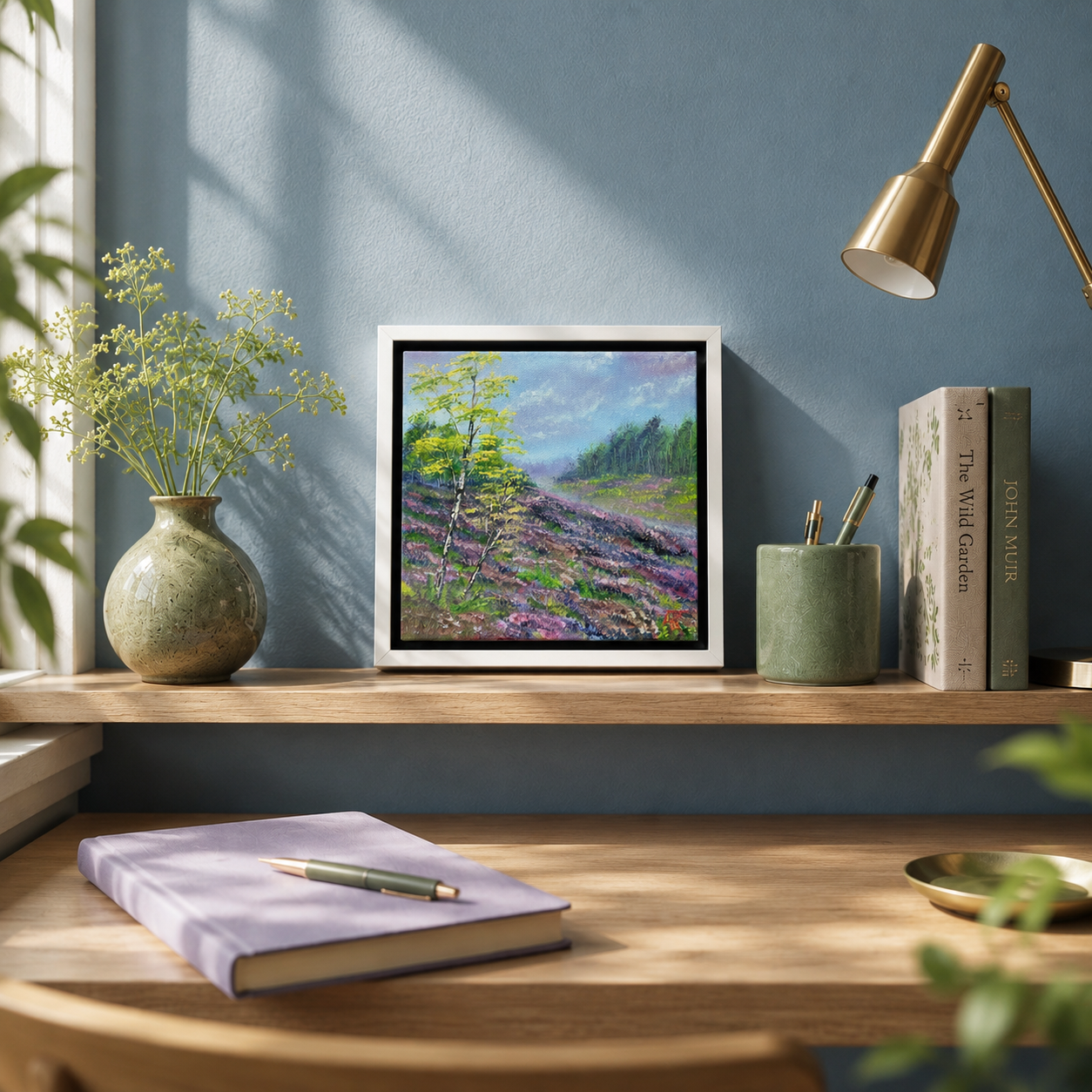 Framed landscape painting on a wooden shelf with books, a vase, and a notebook.