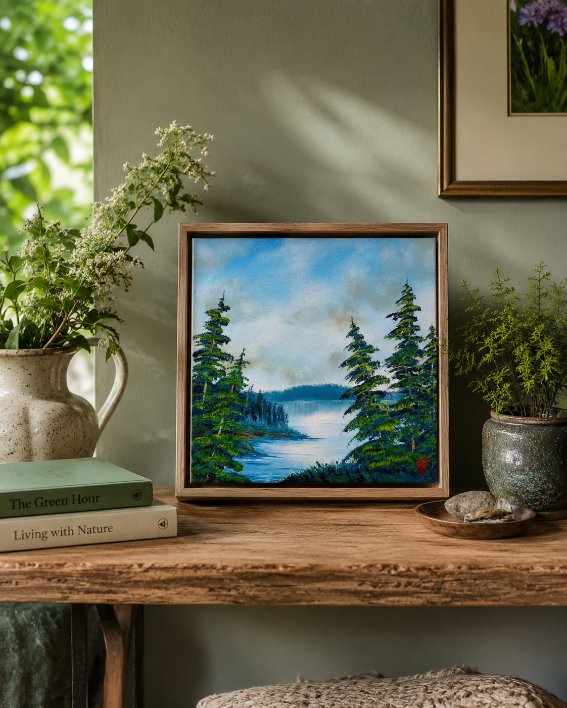 Framed nature oil painting on a wooden shelf with plants and books.
